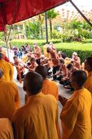 Bandung, Indonesia, 2020 - The monks in orange rob standing in order while praying to the god at the altar inside the Buddha temple photo