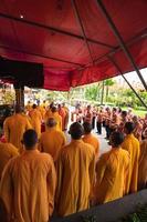 Bandung, Indonesia, 2020 - The monks in orange rob standing in order while praying to the god at the altar inside the Buddha temple photo