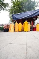 Bandung, Indonesia, 2020 - The monks in orange rob standing in order while praying to the god at the altar inside the Buddha temple photo