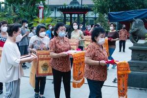 Bandung, Indonesia, 2020 - Buddhist society walking together for praying at the altar with the monks inside the buddha temple photo