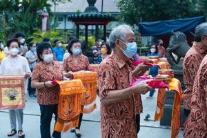 Bandung, Indonesia, 2020 - Buddhist society walking together for praying at the altar with the monks inside the buddha temple photo