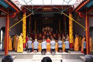 Bandung, Indonesia, 2020 - Buddhist People pray together with the monks while giving the offering in front of the altar photo