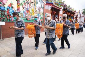 Bandung, Indonesia, 2020 - Buddhist People pray together with the monks while giving the offering in front of the altar photo