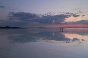 People silhouettes walking through water landscape photo