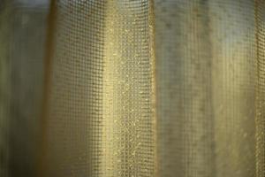 cortinas en la ventana. luz a través de las cortinas. textura de tela estructura de rejilla fina. foto