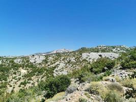 montañas rocosas contra un cielo azul brillante foto