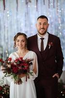 retrato de una joven pareja de recién casados en looks de boda foto
