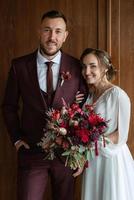 retrato de una joven pareja de recién casados en looks de boda foto