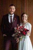 retrato de una joven pareja de recién casados en looks de boda foto