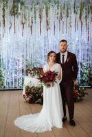 retrato de una joven pareja de recién casados en looks de boda foto