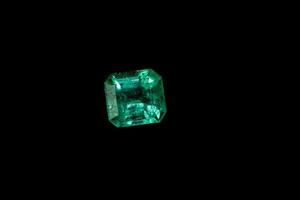 Macro mineral Emerald gemstone faceted on black background photo