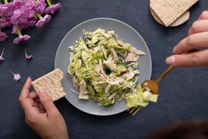 Top view salad of fresh vegetables and meat in a plate on dark stone table. The concept of healthy eating photo