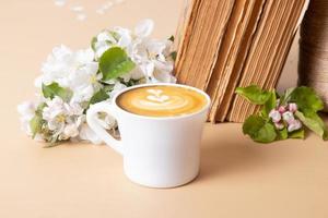 Cup of coffee and blossom apple twigs with vinage books. Springtime still life composition photo