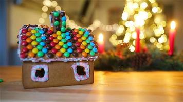 Lebkuchenfeenhaus auf einem Hintergrund von hellem Weihnachtsbaum mit Girlande video