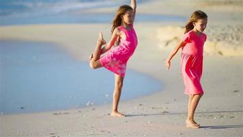 liten flickor har roligt på tropisk strand under sommar semester spelar tillsammans video