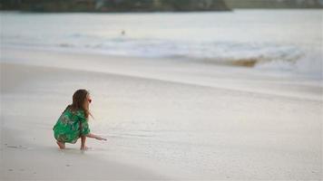 schattig klein meisje veel plezier op tropisch strand tijdens vakantie video