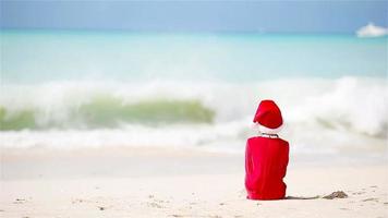 Adorable girl in Christmas hat on white beach during Xmas vacation video