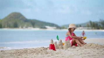 entzückendes kleines mädchen, das im strandurlaub mit spielzeug spielt video