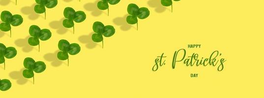 Happy St. Patrick's Day text with clover leaf pattern on colored background. Greeting banner photo