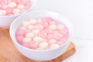 Tang yuan, tangyuan, delicious red and white rice dumpling balls in a small bowl. Asian traditional festive food for Chinese Winter Solstice Festival, close up. photo