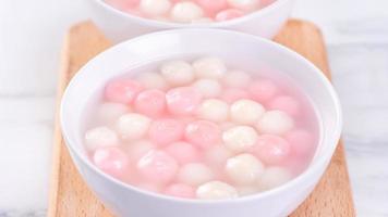 Tang yuan, tangyuan, delicious red and white rice dumpling balls in a small bowl. Asian traditional festive food for Chinese Winter Solstice Festival, close up. photo