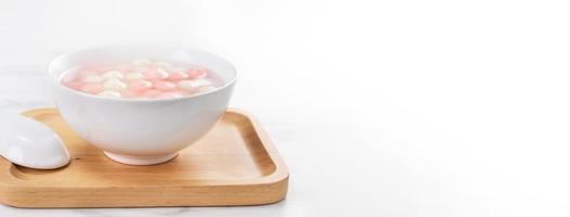 Tang yuan, tangyuan, delicious red and white rice dumpling balls in a small bowl. Asian traditional festive food for Chinese Winter Solstice Festival, close up. photo