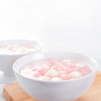 Tang yuan, tangyuan, delicious red and white rice dumpling balls in a small bowl. Asian traditional festive food for Chinese Winter Solstice Festival, close up. photo