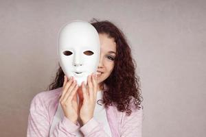 happy girl peeking behind mask photo