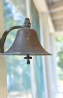 Brass Dinner Bell Hanging on a Porch photo