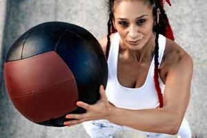 vista desde arriba. mujer atlética con balón médico. fuerza y motivación.foto de mujer deportiva en ropa deportiva de moda foto