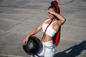 Athletic woman with med ball. Strength and motivation.Photo of sporty  woman in fashionable sportswear photo