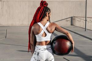 From the back. Athletic woman with med ball. Strength and motivation.Photo of sporty  woman in fashionable sportswear photo