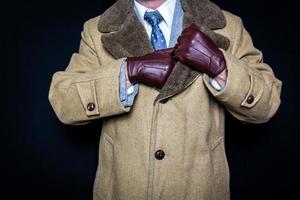 Portrait of Gentleman in Vintage Suite Reaching into Fur Coat. Concept of Secret Agent Spy Hero Film Noir. photo