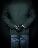 Portrait of Butler in Dark Formal Suit and Leather Gloves Standing with Hands Behind Back on Black Background. Service Industry and Professional Hospitality. photo