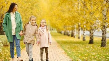 Family of mother and kids in fall. Young mother and little girls enjoy warm autumn video