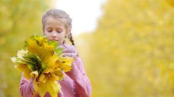 niño feliz con hojas amarillas al aire libre en otoño video