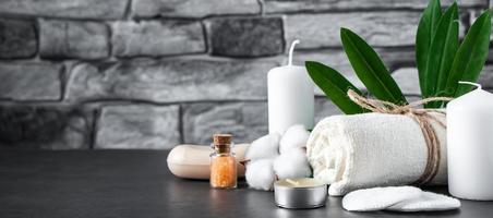Wellness accessories on gray stone background. Towel, candles and aromatic salt. photo