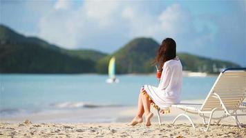 Young woman with tasty cocktail on white beach video