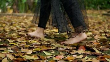 A Woman foot walking on the top of the yellow and brown leaf video