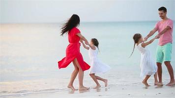 gelukkig mooi familie Aan een strand gedurende zomer vakantie. familie van vier hebben pret Bij zonsondergang Aan de strand video