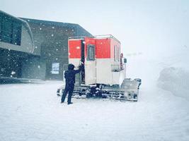 Snowcat con cabina para llevar a los esquiadores snowboarders freeride cuesta abajo en las remotas montañas del Cáucaso. ratrak en la experiencia de goderdzi foto