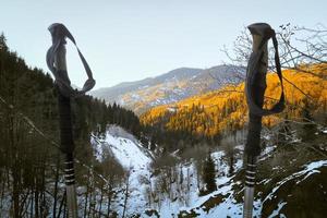 Close up black grey hiking poles on hike with mountains panorama in spring photo