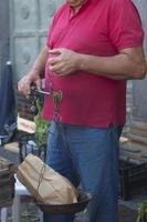 hombre irreconocible usando una báscula tradicional en un mercado callejero foto