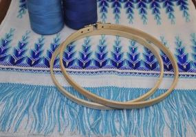 Wooden hoop for embroidery on a table with a thread photo