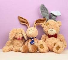 teddy bear in a cap and a cute teddy hare with long ears, a red butterfly tied around his neck photo