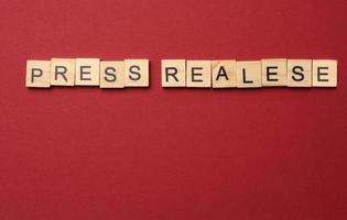 lettering press release made from wooden blocks on a red background photo