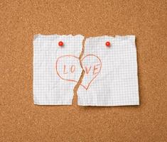 torn white sheet of paper with the inscription love and heart shape photo