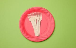 Wooden fork and empty round red disposable plate photo