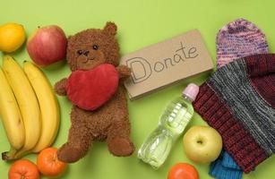 clothes and brown teddy bear on a green background, top view photo