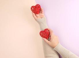 female hands hold red hearts photo